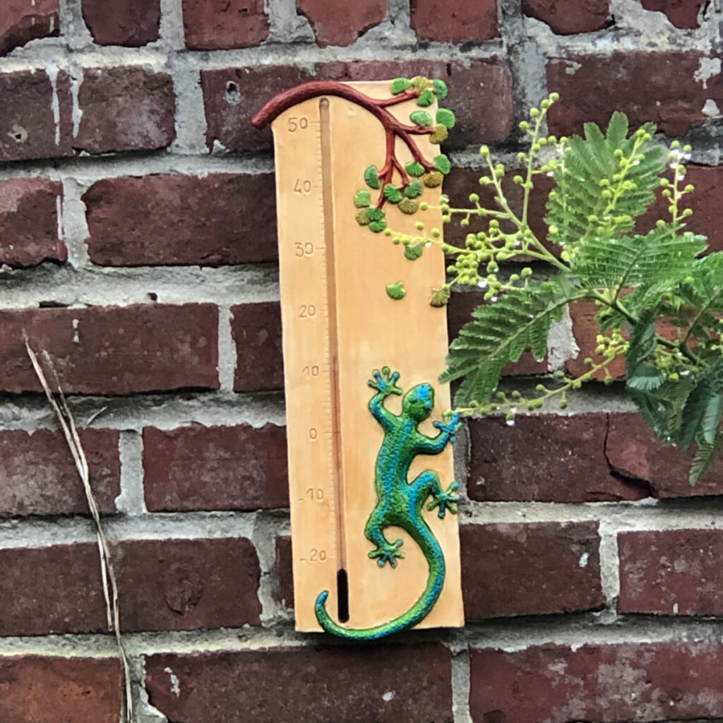 Thermomètre géant gécko en situation sur un mur en brique