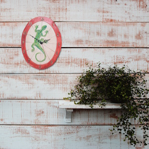 Horloge murale gecko salamandre sur un mur lambrissé